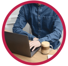 Man working on a laptop with a Nespresso Coffee